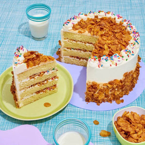 Cereal Milk Cake with 4 layers, cereal milk sponge, buttercream, white chocolate ganache, and cornflake clusters.